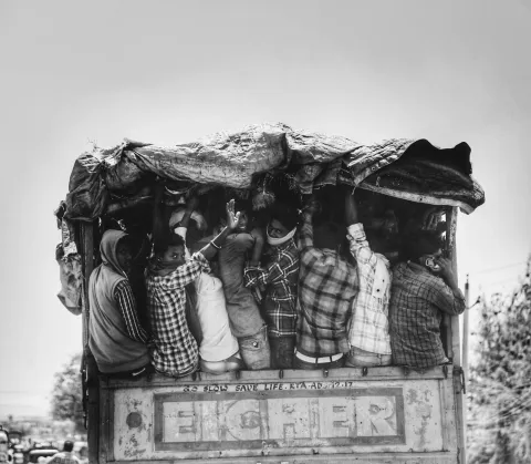 Migrants being transported under overcrowded conditions in vehicles.